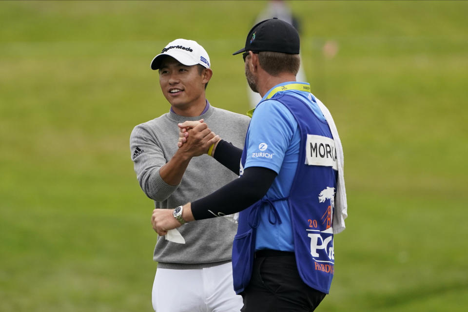 Collin Morikawa greets his caddie Jonathan Jakovac on the 18th hole after their final round of the PGA Championship golf tournament at TPC Harding Park Sunday, Aug. 9, 2020, in San Francisco. (AP Photo/Charlie Riedel)