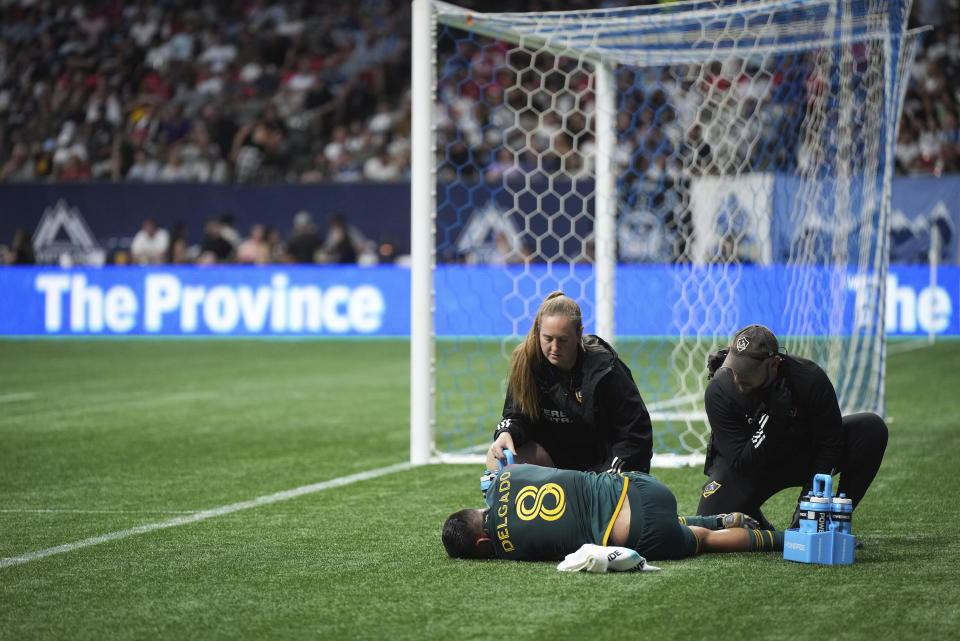 Los Angeles Galaxy's Mark Delgado is tended to by team personnel after being injuredduring the second half of an MLS soccer match against the Vancouver Whitecaps on Saturday, July 15, 2023, in Vancouver, British Columbia. (Darryl Dyck/The Canadian Press via AP)