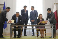 Qatar's Minister of Commerce and Industry Ali bin Ahmed Al Kuwari, second left and Spain's deputy Prime Minister and Economy Minister Nadia Calvino prepare to sign an investment agreement with Spain in the presence of the Emir of Qatar Sheikh Tamim bin Hamad Al Thani, top left and Spain's Prime Minister Pedro Sanchez at the Moncloa Palace in Madrid, Spain, Wednesday, May 18, 2022. The emir of Qatar said that his energy-rich gulf state is set to boost investments in Spain by 4.7 billion euros (4.9 billion) dollars in the coming years, Spanish media reported late on Tuesday. The details of the investments have not been made public but with Europe scrambling to find alternatives to Russian energy, Qatar is positioned to help fill the gap with exports of liquified natural gas. (AP Photo/Paul White)