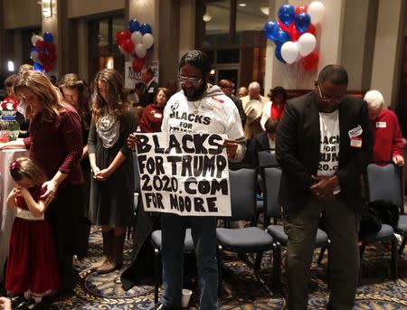 Guests pray during the invocation at Republican U.S. Senate candidate Roy Moore's election night party in Montgomery, Alabama, U.S. December 12, 2017. REUTERS/Carlo Allegri