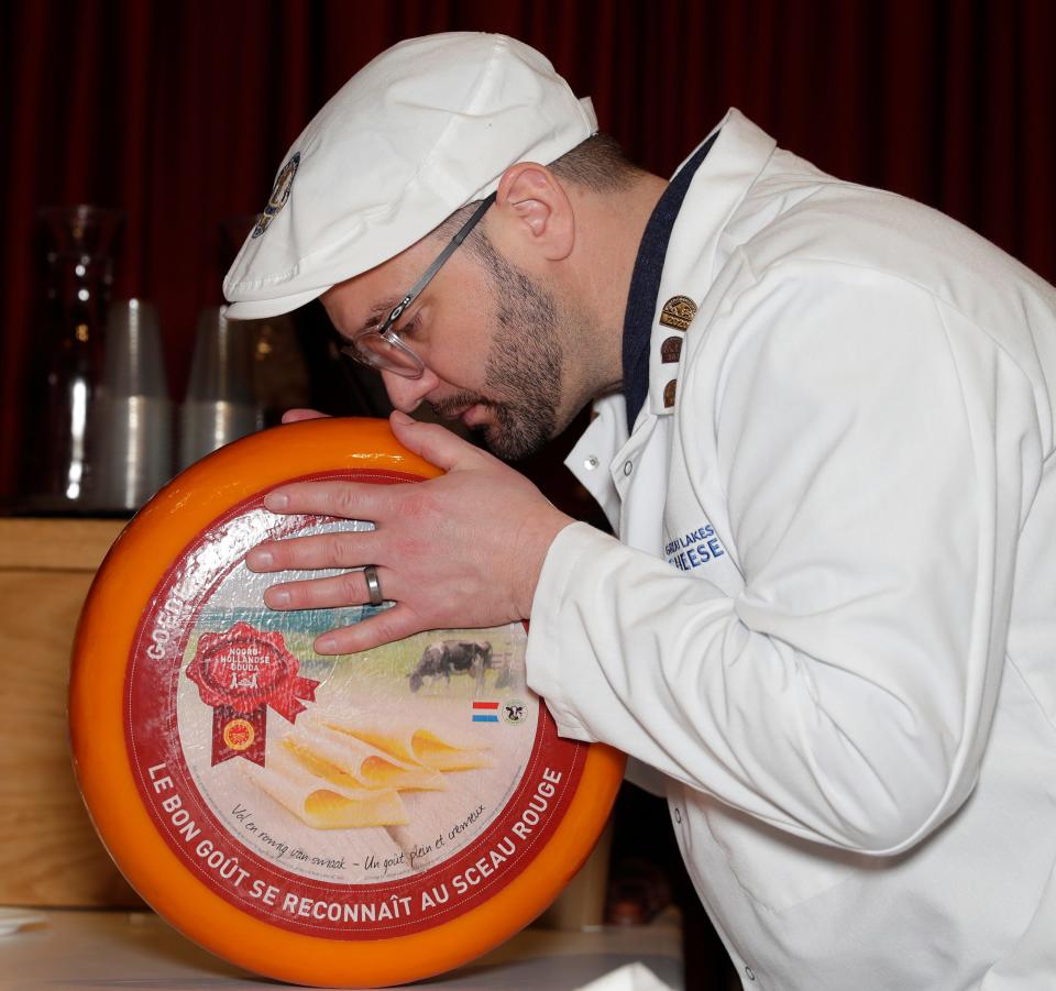 Drew Kordus of Great Lakes Cheese in Wisconsin judges a Gouda cheese Tuesday during the 2024 World Championship Cheese Contest at Monona Terrace Community and Convention Center in Madison.