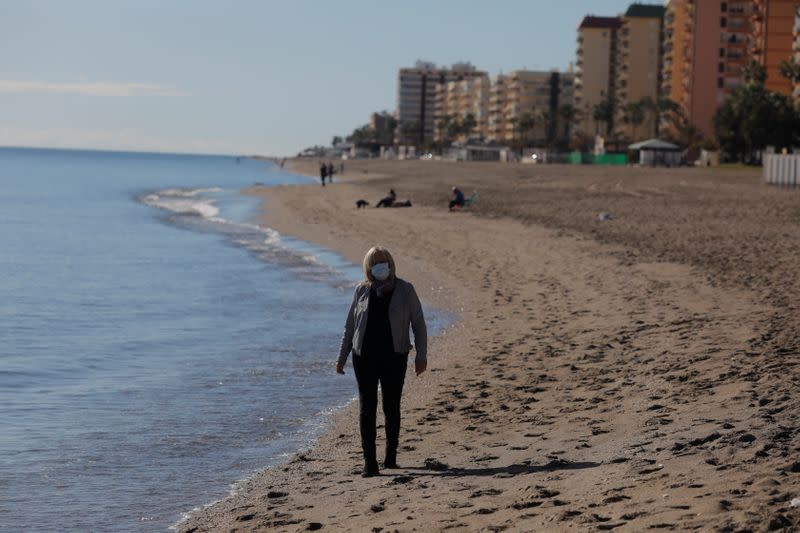 British resident Michelle Jones walks as she poses for a photo in front of the Mediterranean Sea on a beach in Fuengirola