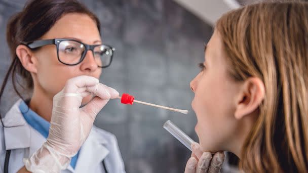 PHOTO: Female pediatrician using a swab to take a sample from a patient's throat (STOCK PHOTO/Getty Images)