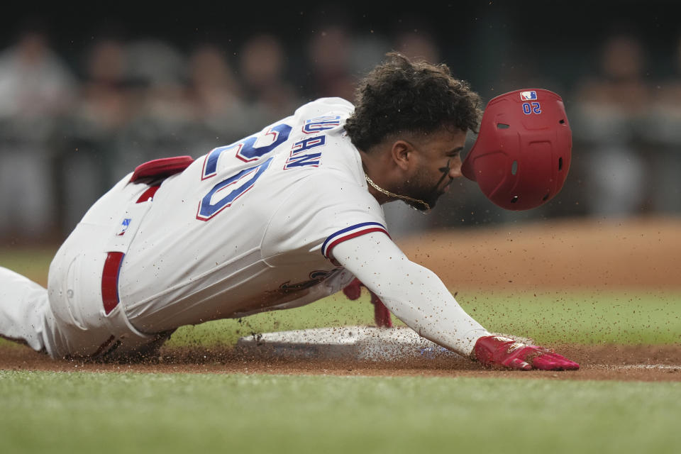 Texas Rangers' Ezequiel Duran slides into first base for a single during the sixth inning of a baseball game against the Detroit Tigers in Arlington, Texas, Tuesday, June 27, 2023. (AP Photo/LM Otero)