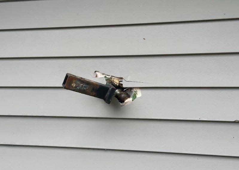 A trailer hitch is embedded in the side of a house on Friday after storms blew through the Crestview area.