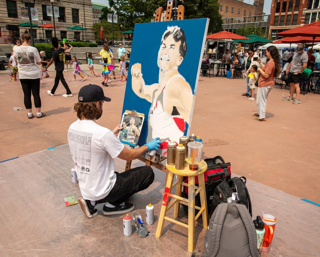 Artist Dave "Croc" O'Connor paints a portrait of Worcester's two-time Olympic medalist Stephen Nedoroscik during the final Out To Lunch festival and farmers market on the Common Thursday.