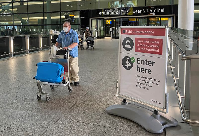A passenger walks through a terminal at Heathrow Airport, as Britain launches its 14-day quarantine for international arrivals, following the outbreak of the coronavirus disease (COVID-19), London, Britain