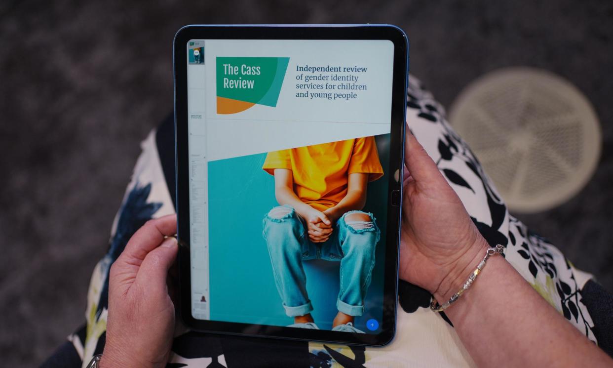 <span>Retired consultant paediatrician Dr Hilary Cass holds a tablet showing her report.</span><span>Photograph: Yui Mok/PA</span>