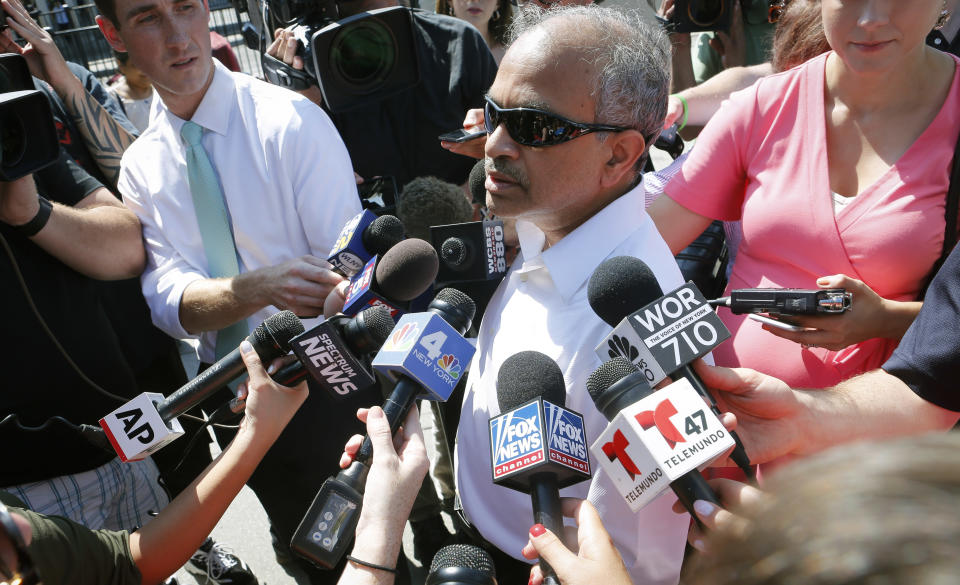 Sranivasa Rao, center, from Floral Park, Queens, N.Y., update reporters about his flight aboard an Emirates airline after an emergency was declared when the plane landed at JFK Airport with ill passengers on a flight from Dubai, Wednesday, Sept. 5, 2018, in New York. (AP Photo/Bebeto Matthews)