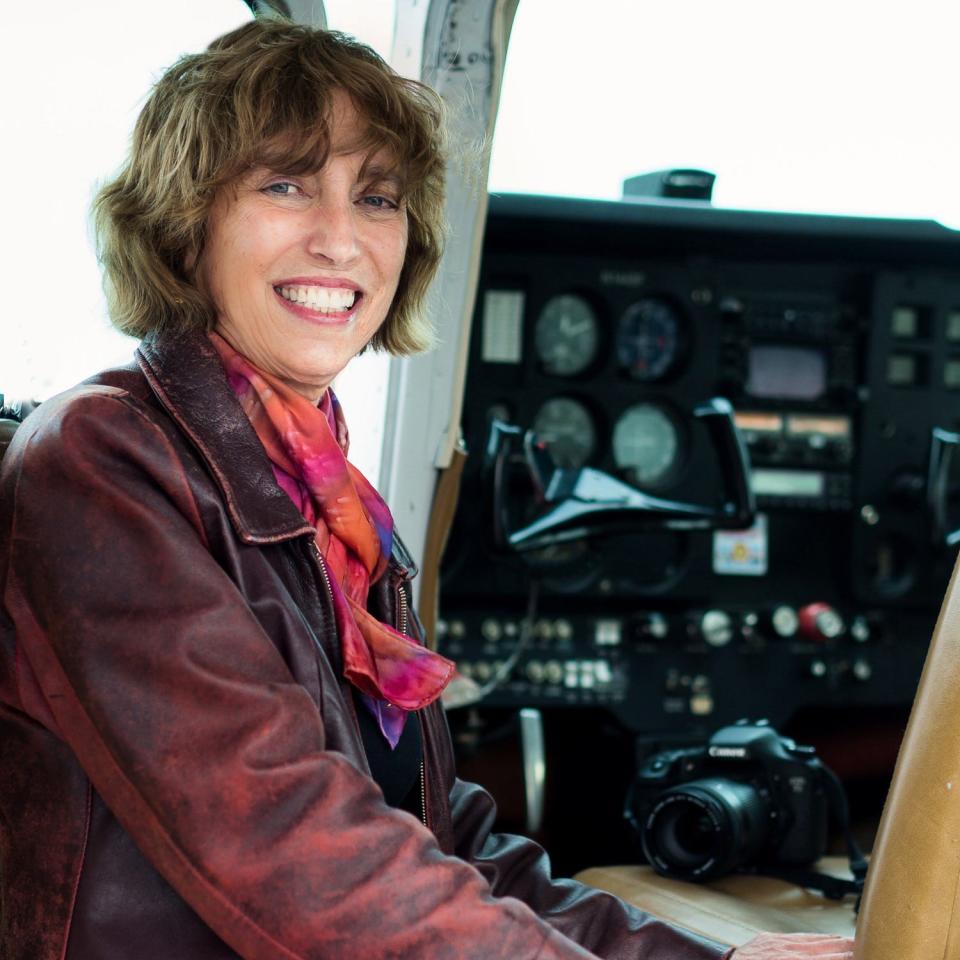 Margot Cheel is next to the cockpit in a plane.
