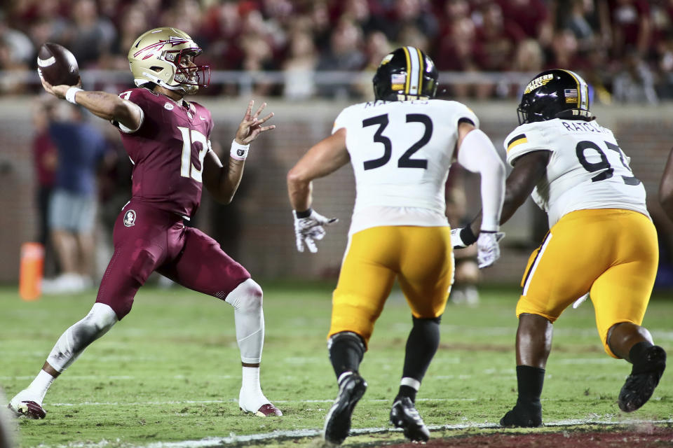 Florida State quarterback Jordan Travis (13) looks to throw a pass as Southern Mississippi linebacker Hayes Maples (32) and defensive tackle Josh Ratcliff (93) close in during the first quarter of an NCAA college football game Saturday, Sept. 9, 2023, in Tallahassee, Fla. (AP Photo/Phil Sears)