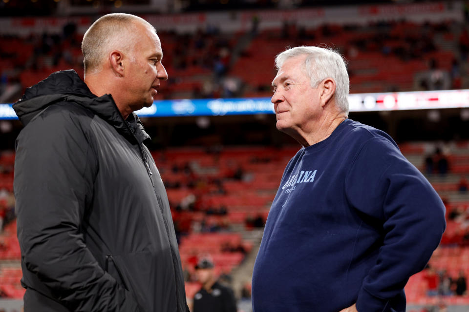 RALEIGH, NORTH CAROLINA - NOVEMBER 25: Head coach Mack Brown (R) of the North Carolina Tar Heels talks with head coach Dave Doeren of the NC State Wolfpack prior to the game at Carter-Finley Stadium on November 25, 2023 in Raleigh, North Carolina. NC State won 39-20. (Photo by Lance King/Getty Images)