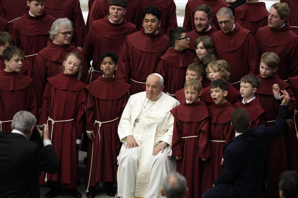 Pope Francis poses for photos with the young members of a chorus at the end of his weekly general audience in the Paul VI Hall, at the Vatican, Wednesday, Feb. 28, 2024. (AP Photo/Andrew Medichini)
