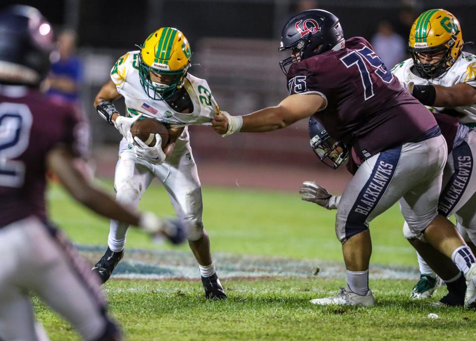 Coachella Valley's Aaron Ramirez (23) runs the ball as La Quinta's Jonathan Patlan (75) grabs a hold of him to bring him down during the third quarter of their game at La Quinta High School in La Quinta, Calif., Friday, Sept. 2, 2022. 