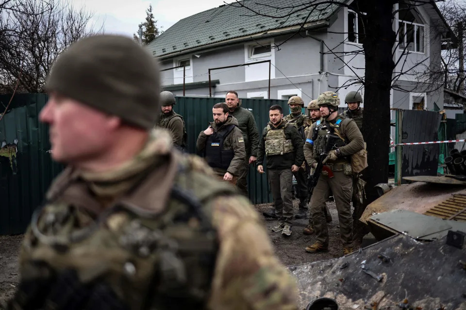 Ukrainian President Volodymyr Zelensky walks with soldiers.