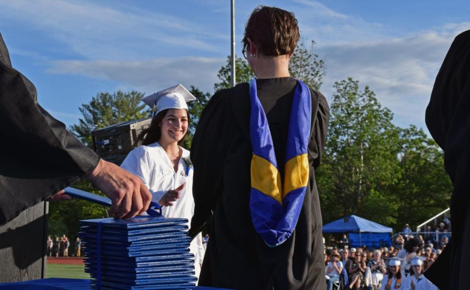 Graduate Elizabeth Velardi smiles as she takes the stage to receiver her diploma from Principal Rebecca Noe.