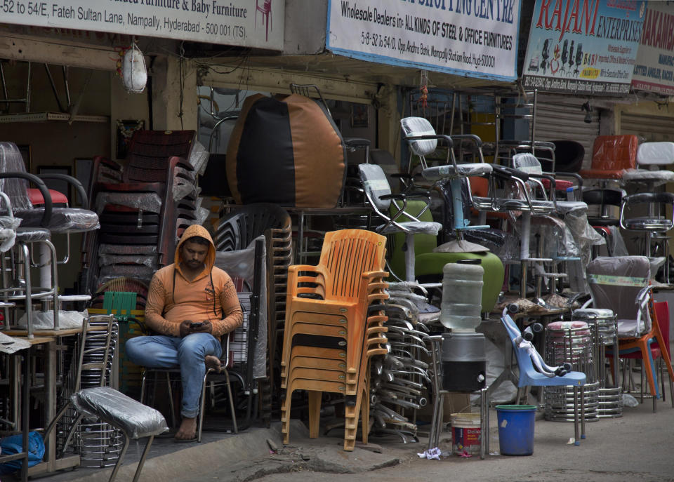 In this Dec. 17, 2018, photo, a salesman checks his mobile phone as he waits for customers at the Nampally furniture market in Hyderabad, India. Such markets are the competition Swedish giant Ikea faces in tackling the $40 billion Indian market for home furnishings, which is growing quickly along with the country’s consumer class. Ikea says India is a test case for whether Ikea should keep shifting resources toward emerging economies, including Latin America and China, given the saturation of markets in Europe and the United States, and the possibility of another global recession. (AP Photo/Mahesh Kumar A.)