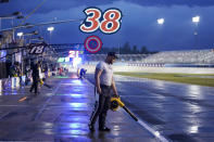 Jourdan Osinskie, the jack man on the pit crew for driver Todd Gilliland, tries to dry off their pit box during a storm delay at a NASCAR Cup Series auto race Sunday, June 26, 2022, in Lebanon, Tenn. (AP Photo/Mark Humphrey)