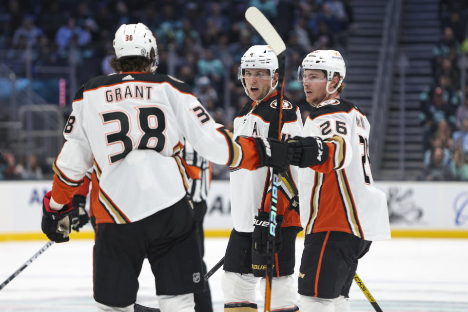 Anaheim Ducks center Derek Grant (38) and defenseman Cam Fowler (4) celebrate after a goal by left wing Brock McGinn (26) during the second period of an NHL hockey game against the Seattle Kraken, Thursday, March 30, 2023, in Seattle. (AP Photo/Jason Redmond)