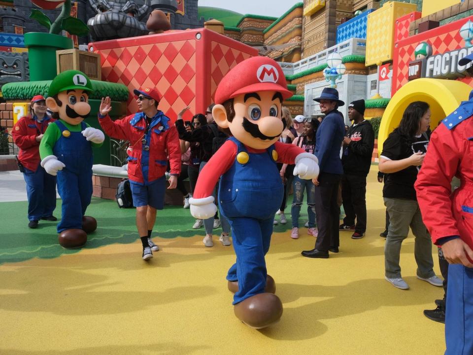 Mario and Luigi are escorted through the crowd on their way to a break during a preview of Super Nintendo World at Universal Studios in Los Angeles, California, on January 13, 2023.