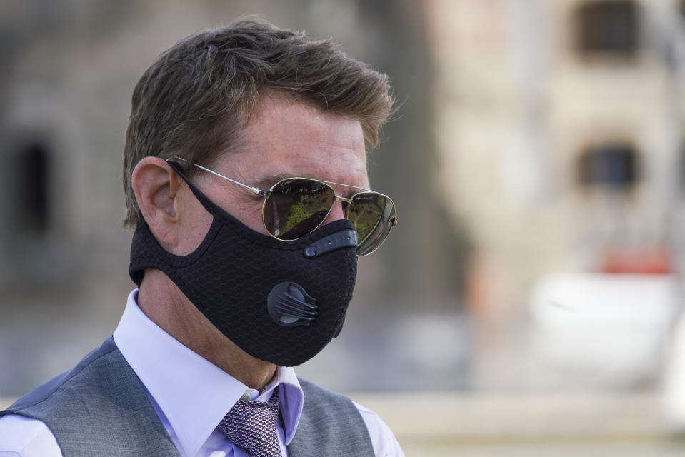 Actor Tom Cruise wears a face mask to prevent the spread of COVID-19 as he greets fans during a break from shooting Mission Impossible 7, along Rome's Fori Imperiali avenue, Tuesday, Oct. 13, 2020. (AP Photo/Andrew Medichini)