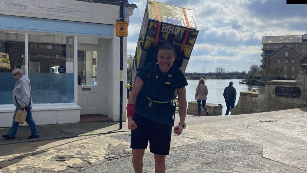 Laura Bird while training with a fridge on her back 