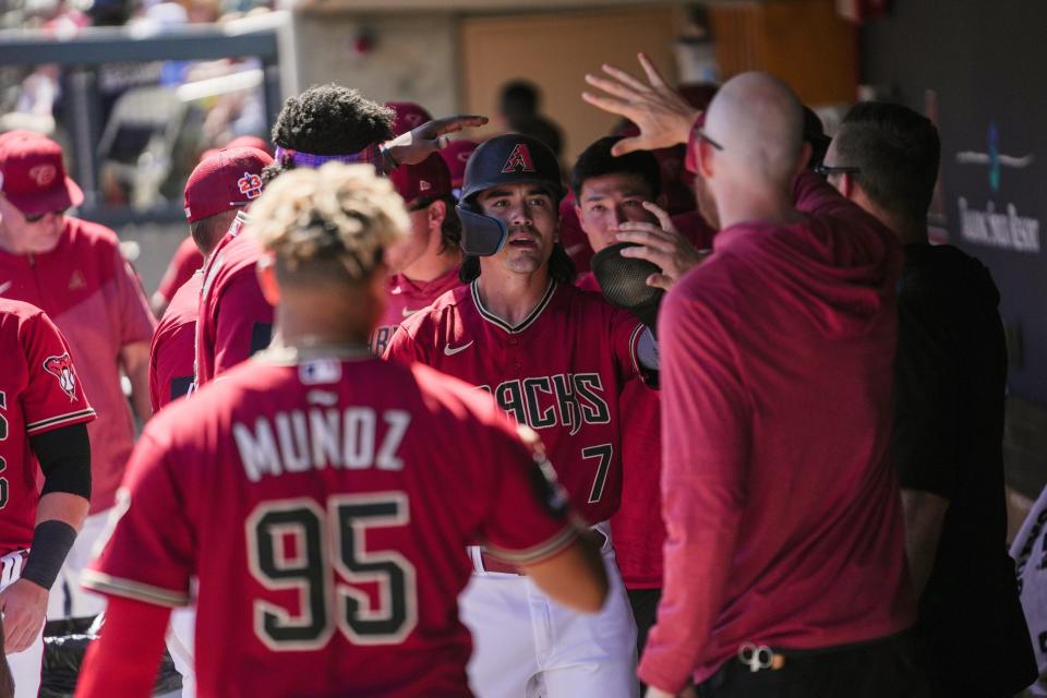 Diamondbacks outfielder Corbin Carroll is congratulated after scoring a run against the Colorado Rockies at Salt River Fields on March 12.