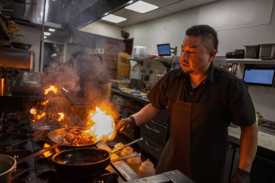 Fabian Arias of La Cosecha grills meat with a traditional gas stove on Wednesday. La Cosecha owner Ernesto Delgado was impressed with electric-powered industrial equipment that is environmentally safer and is considering equipping his future restaurants with electric cookers.