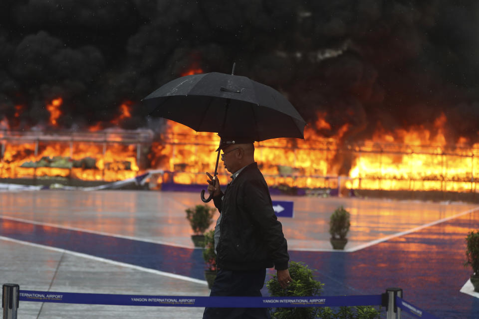 A police walks past while smokes and flames billow from burning illegal narcotics during a destruction ceremony marking International Day against Drug Abuse and Illicit Trafficking on the outskirts of Yangon, Myanmar, Monday, June 26, 2023.(AP Photo/Thein Zaw)