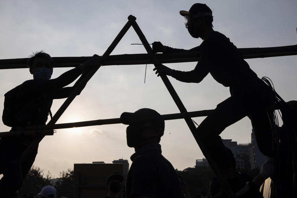 Protesters build additional barrier on a bridge which leads into the Chinese University of Hong Kong, in Hong Kong, Wednesday, Nov. 13, 2019. University students from mainland China are fleeing Hong Kong, and classes in primary and secondary schools have been suspended as clashes turn increasingly violent in the city's 5-month-long anti-government unrest. (AP Photo/Ng Han Guan)