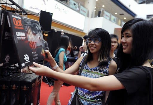 Fans check out mousepads at the launch of Diablo III, the latest edition of one of the biggest videogame franchises of all time, in a computer mall in Singapore on May 15, 2012. Thousands of people were waiting outside the mall, many of them taking time off from work or school to grab their copies. (AFP Photo/Simin Wang)