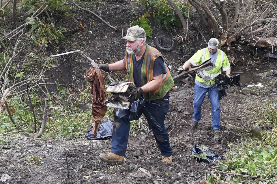 FILE — Recovery crews remove debris from the scene of a fatal crash, Oct. 7, 2018, where a limousine crashed into a parked and unoccupied SUV killing 20 people at an intersection a day earlier, in Schoharie, N.Y. On Wednesday, Aug. 31, 2022, a judge rejected a plea agreement that would have meant no prison time for the operator of the limousine company involved the crash, drawing applause and tears from victims' relatives who packed the court. (AP Photo/Hans Pennink, File)