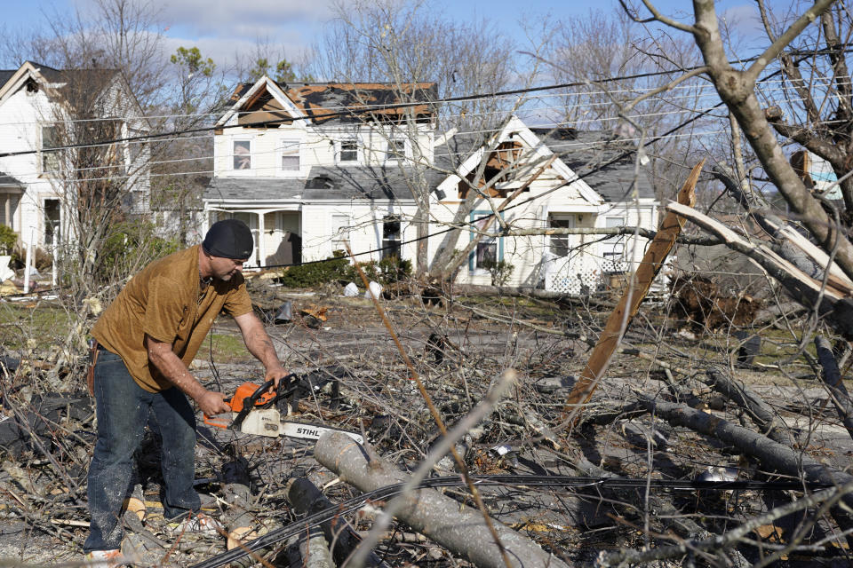 Samuel Hullar usa una motosierra para quitar árboles caídos a lo largo de Nesbitt Lane debido a tormentas y tornados, el 10 de diciembre de 2023, en Nashville, Tennessee. (Foto AP/George Walker IV)