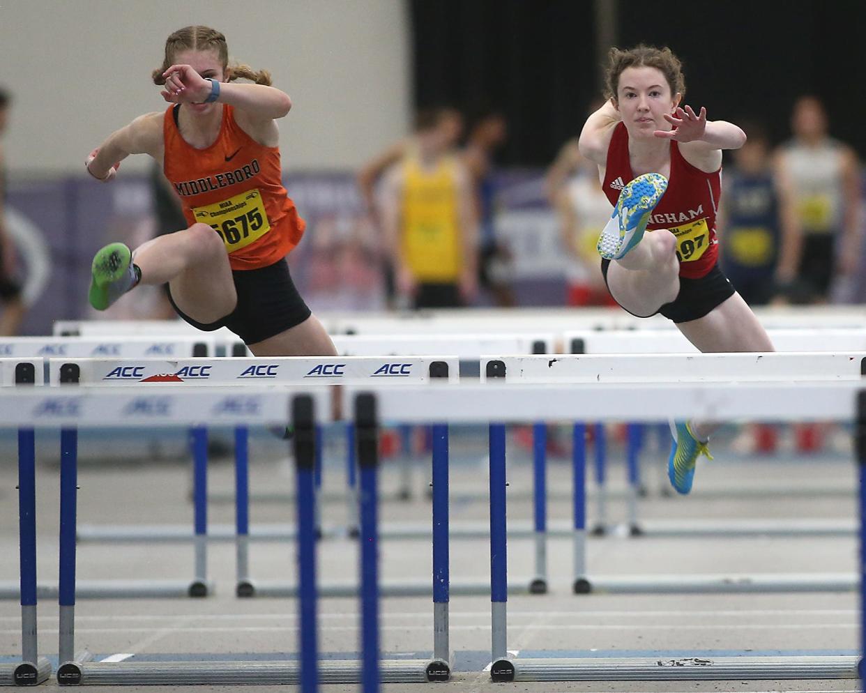 Hingham’s Emma Mills and Middleborough’s Isabel Wheeler leap over the hurdle during the preliminary round of the 55 meter hurdles at the MIAA Meet of Champions at the Reggie Lewis Track Center in Boston on Saturday, Feb. 25, 2023.