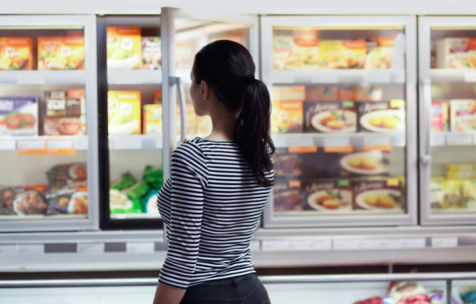 Women choosing a dairy products at supermarket. Reading product information