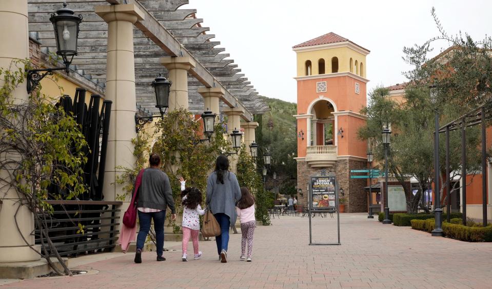 A family walks toward the tower at the Simi Valley Town Center mall on Friday. Developers have been talking to city officials about adding residential units to the shopping center, where some storefronts stand vacant.