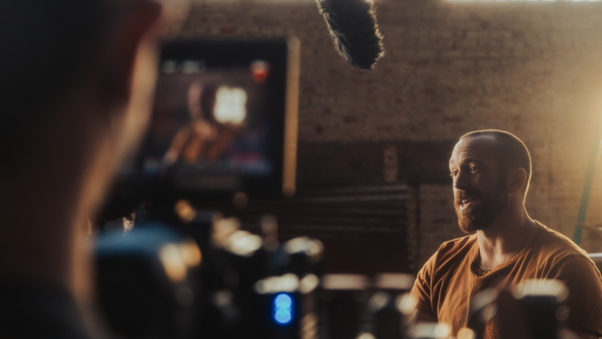  Man speaking in front of a microphone and laptop 