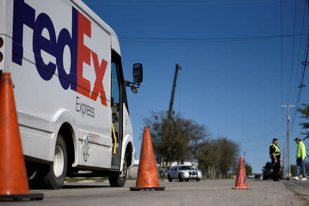 A FedEx truck is held from entering the scene of a blast at a FedEx facility in Schertz, Texas, U.S., March 20, 2018. REUTERS/Sergio Flores