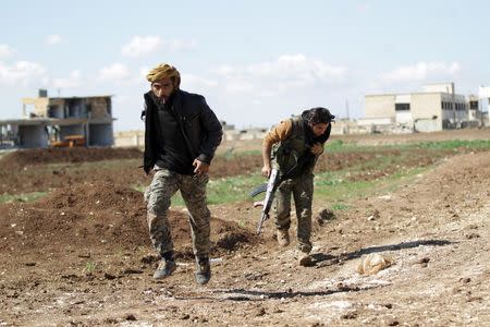 Rebel fighters from 'Jaysh al-Sunna' run fearing snipers loyal to Syria's President Bashar Al-Assad in Tel Mamo village, in the southern countryside of Aleppo, Syria March 6, 2016. REUTERS/Khalil Ashawi