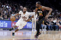 Cleveland Cavaliers guard Darius Garland (10) drives around Phoenix Suns forward Kevin Durant (35) during the second half of an NBA basketball game in Phoenix, Wednesday, April. 3, 2024. (AP Photo/Darryl Webb)