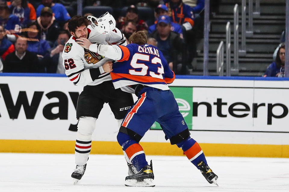 New York Islanders centerman Casey Cizikas (53) and Chicago Blackhawks center Reese Johnson (52) fight during the first period of an NHL hockey game on Sunday, Dec. 4, 2022, in Elmont, N.Y. (AP Photo/Eduardo Munoz Alvarez)