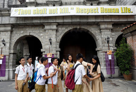 Students gather below a banner outside a church in the Philippine town of Pateros, Metro Manila, Philippines March 15, 2017. Picture taken March 15, 2017. REUTERS/Erik De Castro
