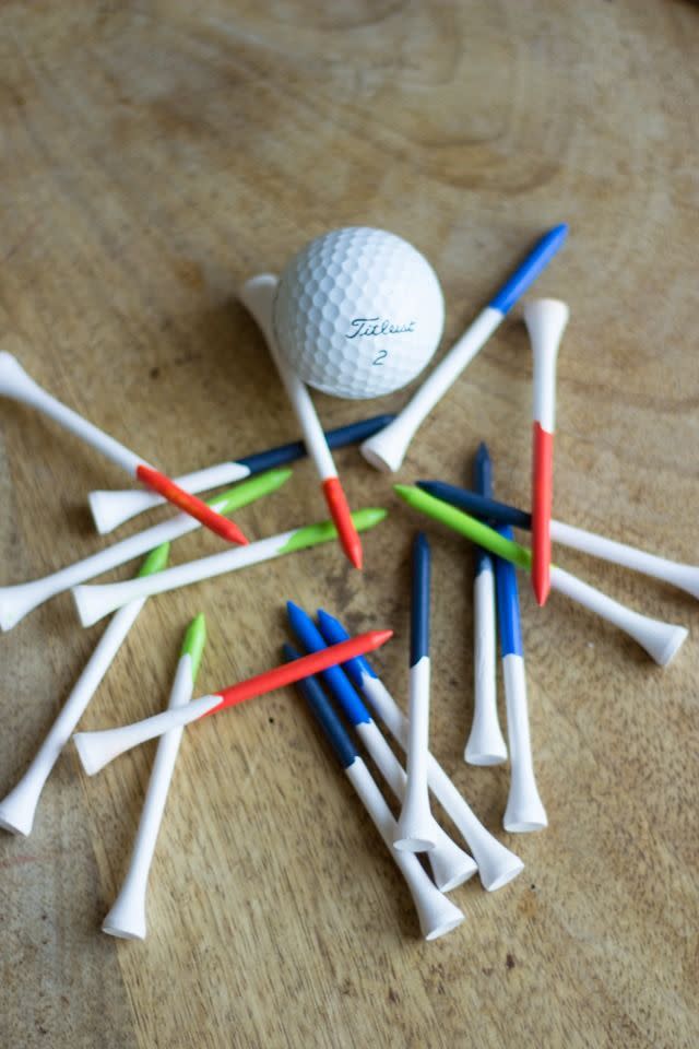 a pile of hand painted golf tees surrounding a golf ball