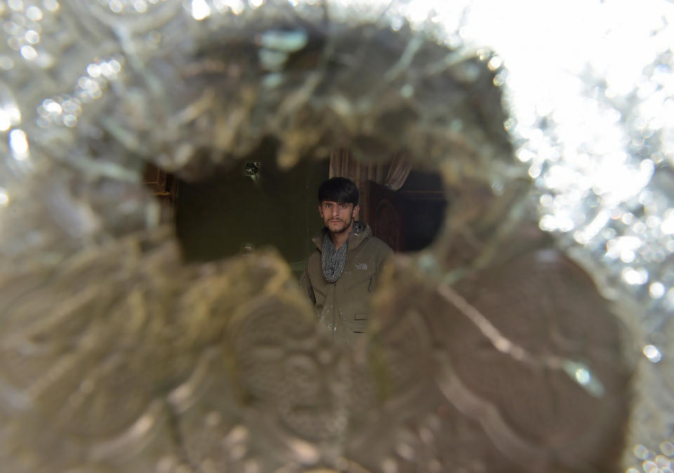 A man is&nbsp;seen through a broken glass at the Kabul house of a parliament member, Mir Wali, on Dec. 22, 2016. Eight people were killed when Taliban gunmen stormed the residence the day before, but Wali survived. The three assailants also were killed following a nearly 10-hour siege.