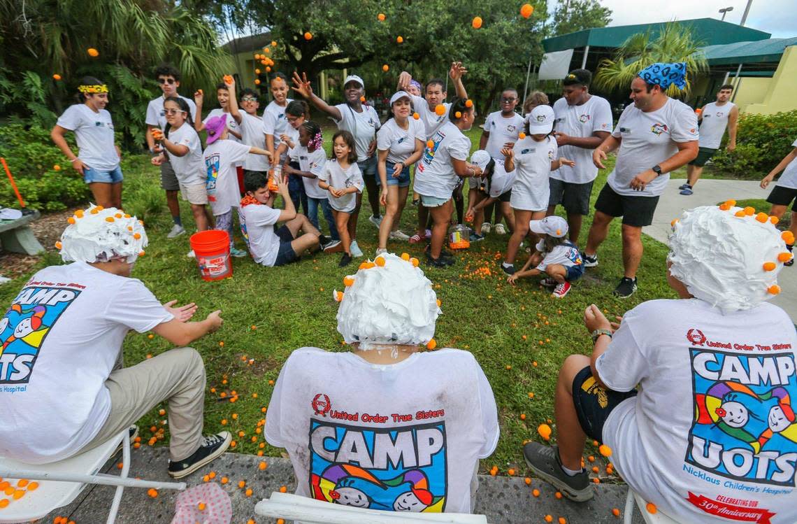 Participants toss cheese balls at the heads of kids lathered in shaving cream at Camp U.O.T.S. on July 23.