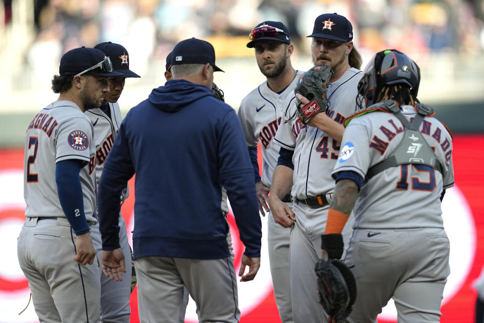 Houston Astros relief pitcher Ryne Stanek, second from right, talks with teammates and pitching coach Joshua Miller during the 10th inning of the team's baseball game against the Minnesota Twins, Friday, April 7, 2023, in Minneapolis. (AP Photo/Abbie Parr)