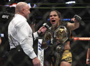 Joe Rogan interviews Amanda Nunes after her victory over Julianna Pena in a mixed martial arts women's bantamweight title bout at UFC 277 on Saturday, July 30, 2022, in Dallas. (AP Photo/Richard W. Rodriguez)