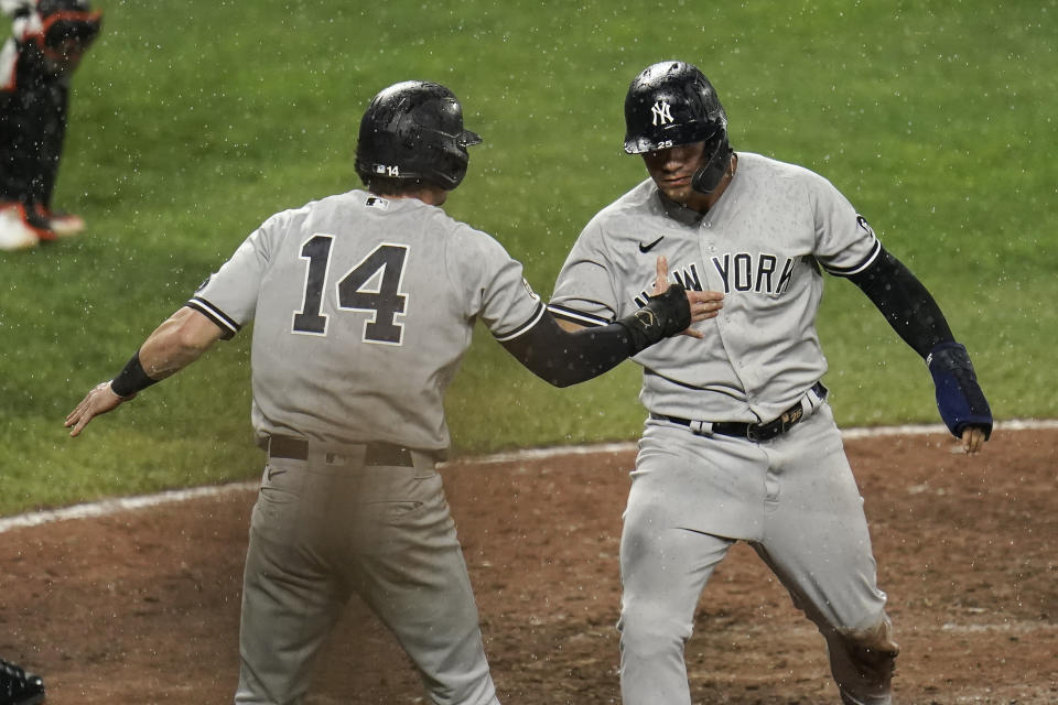 New York Yankees' Tyler Wade (14) and Gleyber Torres celebrate after they both scored on a two-run double by Brett Gardner during the ninth inning of a baseball game against the Baltimore Orioles, Wednesday, Sept. 15, 2021, in Baltimore. (AP Photo/Julio Cortez)