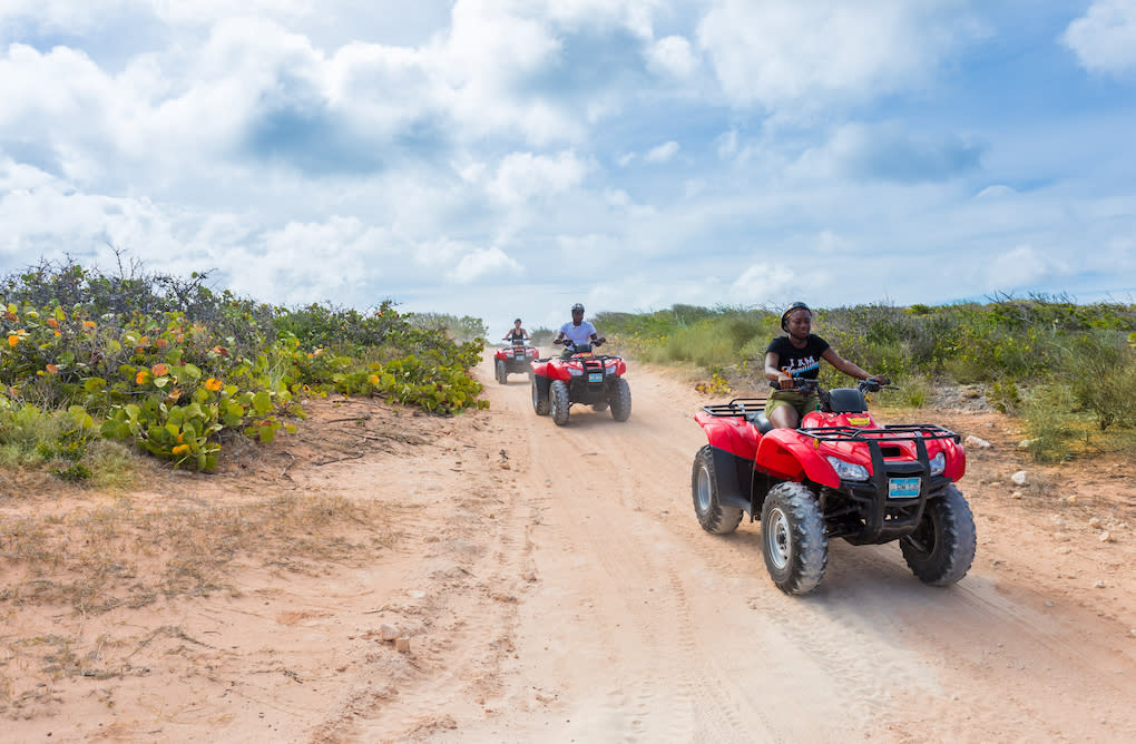 people riding ATVs on a dirt path