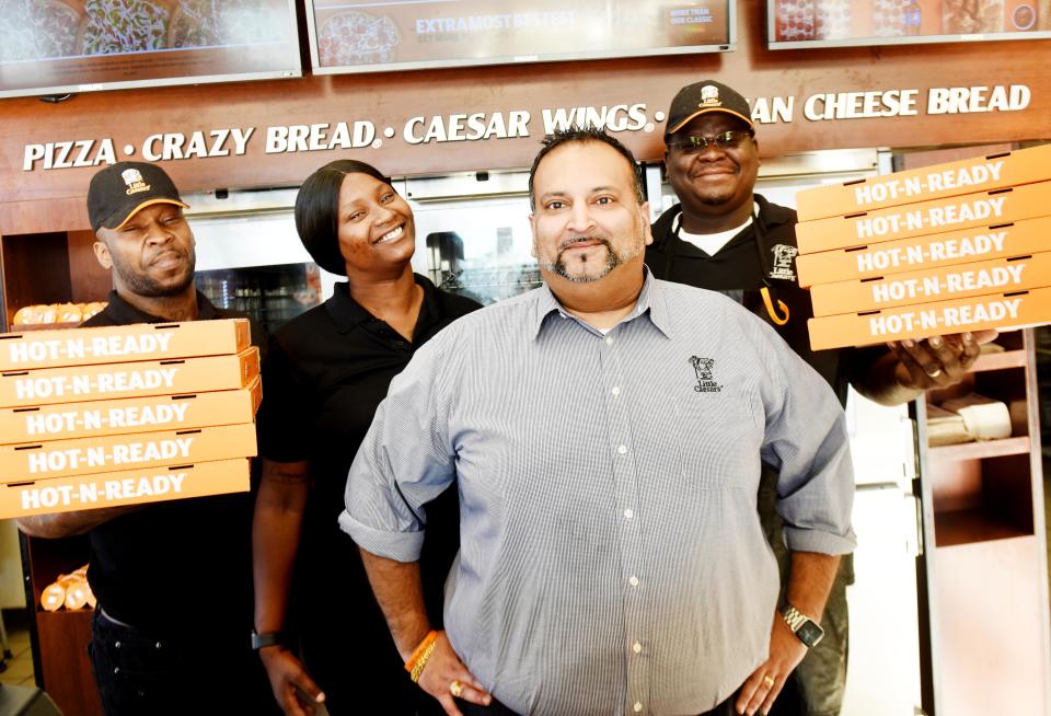 Vinnie Patel (second from right), is photographed with his Little Caesars employees Jetravias Maddox, Tearra Webb, and David Smith on January 13, 2022.